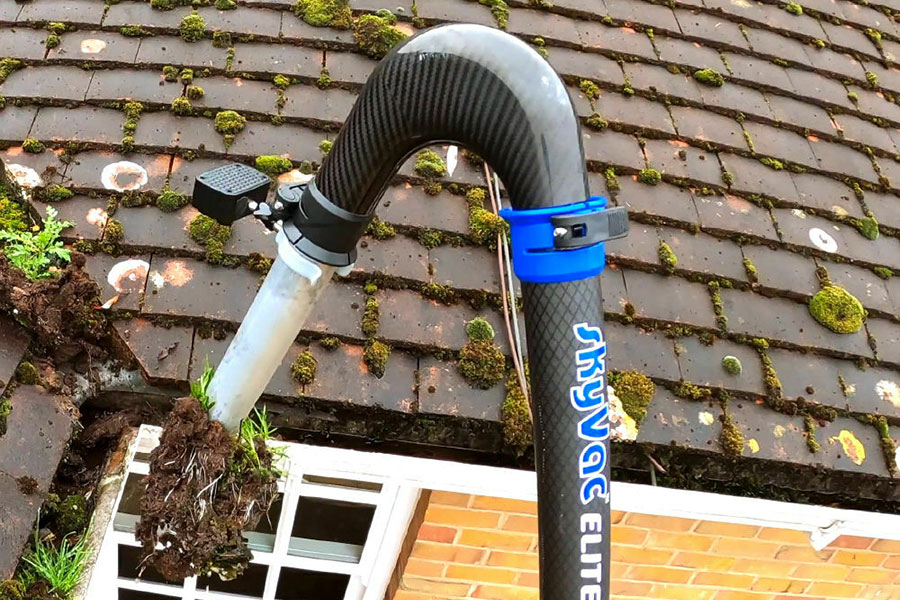 skyvac removing debris from a roof gutter